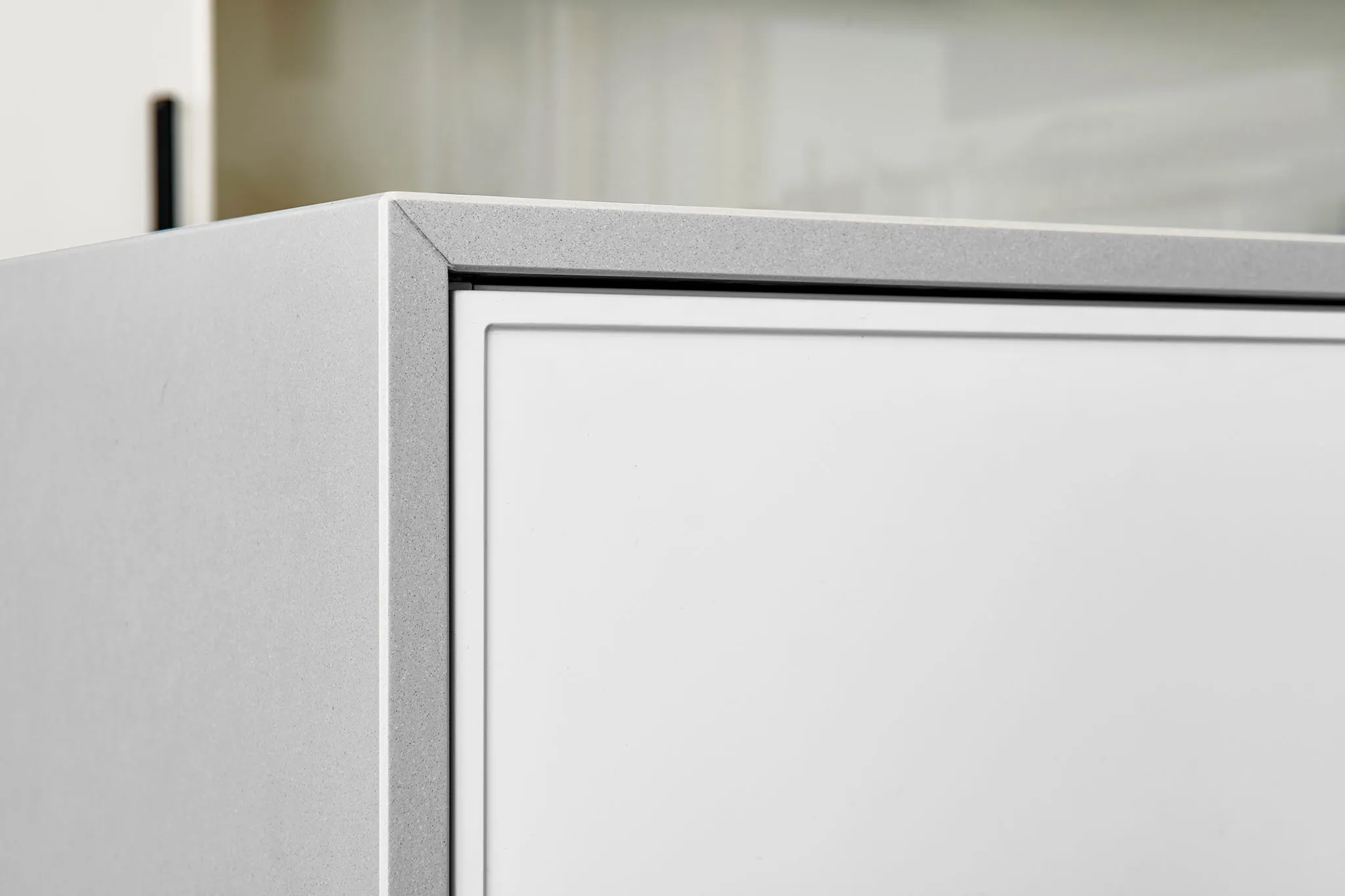 Detail kuchyňské linky a její šedé pracovní desky.